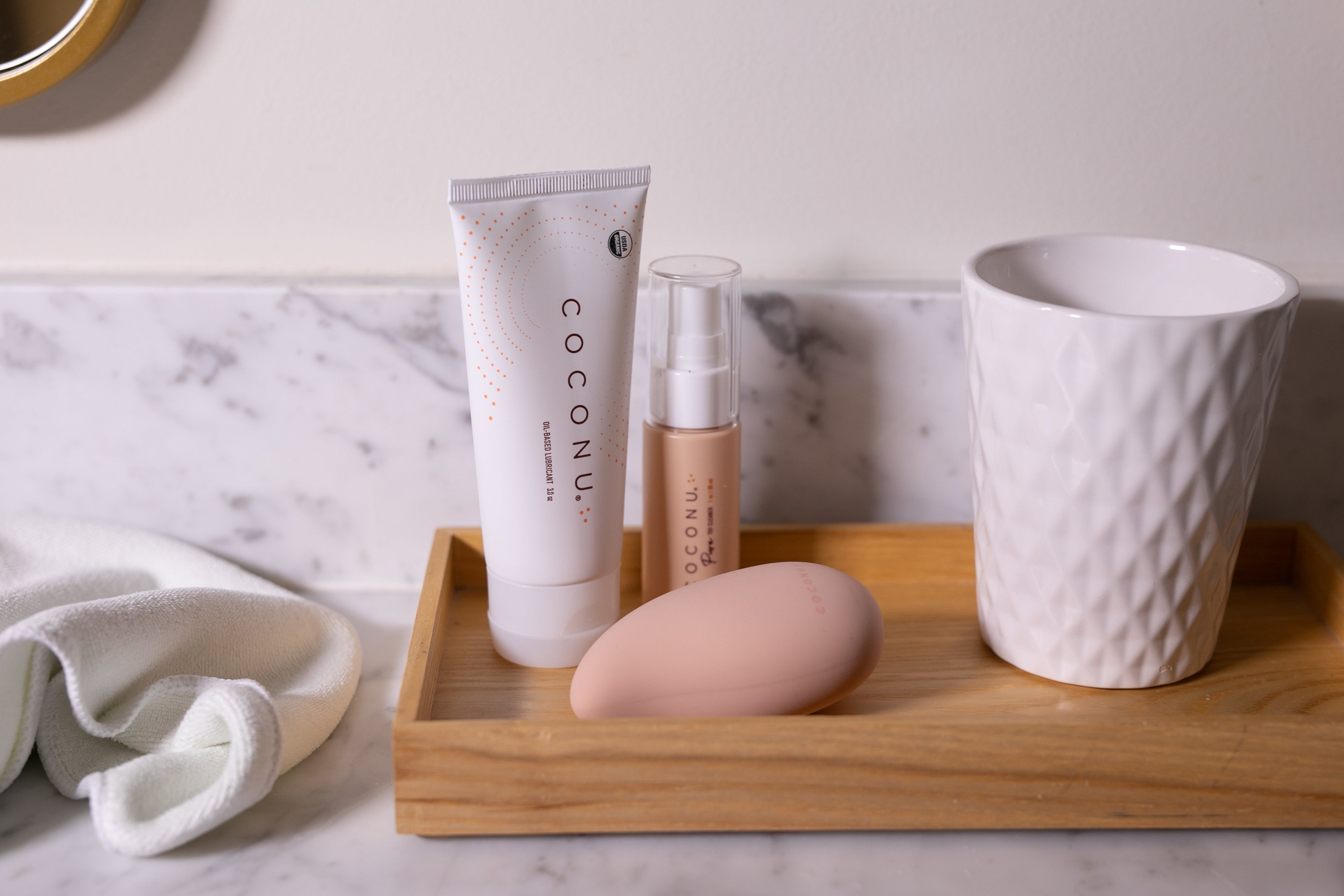 Minimal personal care products in a calm setting, representing an intentional approach to intimate care