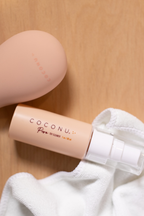 Coconu Pure toy cleaner and the peach Wave massager on a white towel