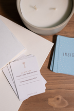 Coconu Connect prompt cards spread on a wooden table beside a lit candle