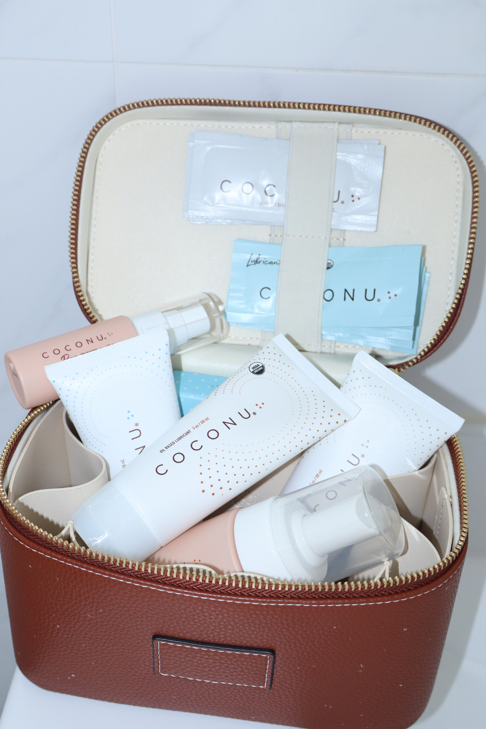 Open travel case packed with Coconu tubes, sachets and pump bottles