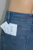 Two Coconu single-use sachets tucked into the back pocket of blue jeans