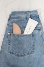 Coconu Wave massager and a Coconu tube in the back pocket of blue jeans