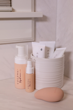 Coconu pumps and single sachets in a ribbed cup on a bathroom shelf, Wave alongside