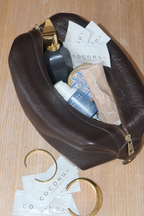 Coconu single sachets in a brown leather pouch with gold jewellery
