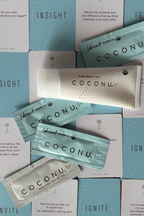 Coconu tube and single sachets laid over Coconu Connect card boxes