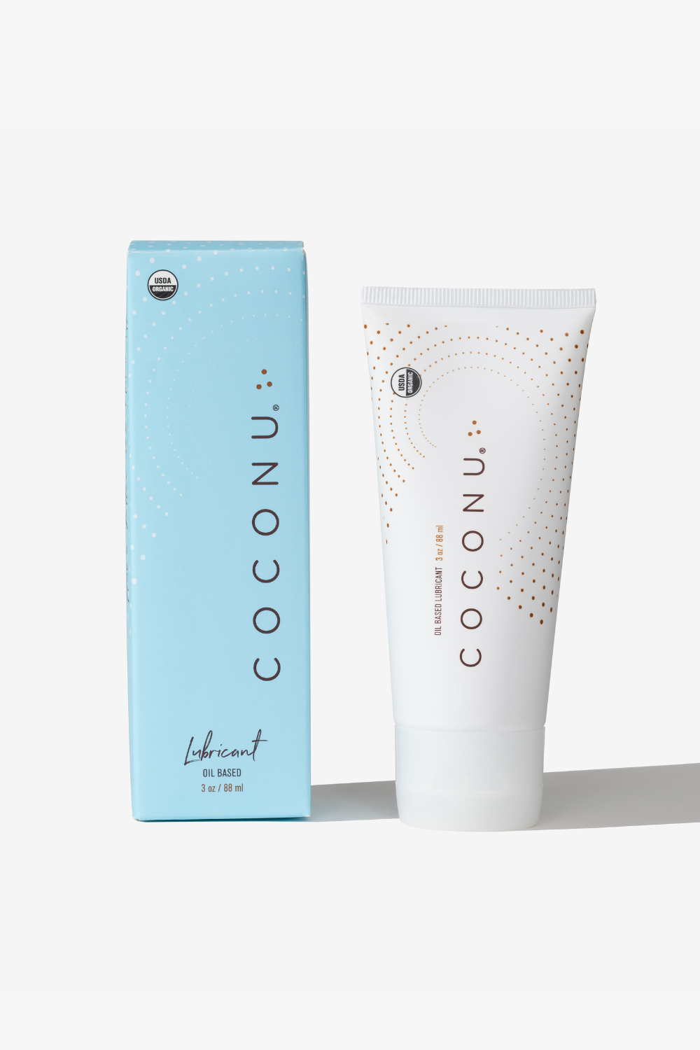 Coconu oil-based lubricant tube standing beside its blue carton